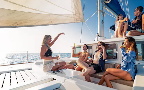 Group enjoying drinks on a catamaran during the Isla Mujeres tour.