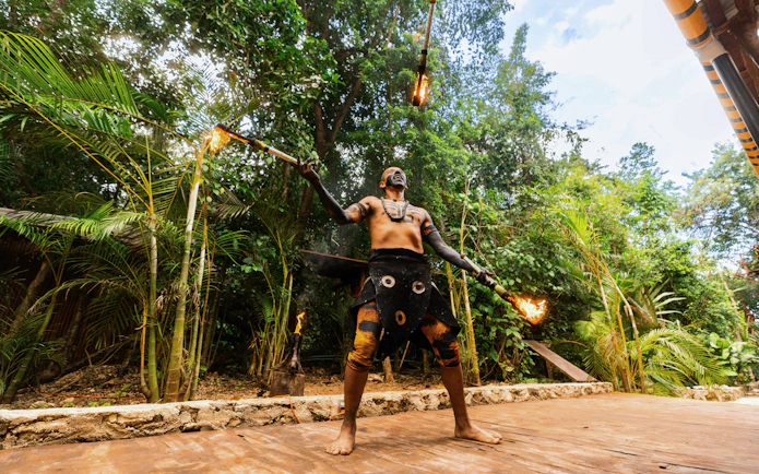 Performer juggling fire at Cancun Extreme Adventuring Park.