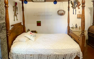 Frida Kahlo Museum bedroom with wooden bed and decorative skeleton on wall.