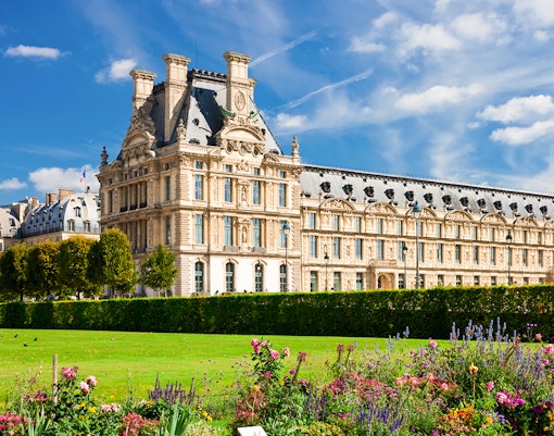Louvre Museum exterior with gardens in Paris, France.