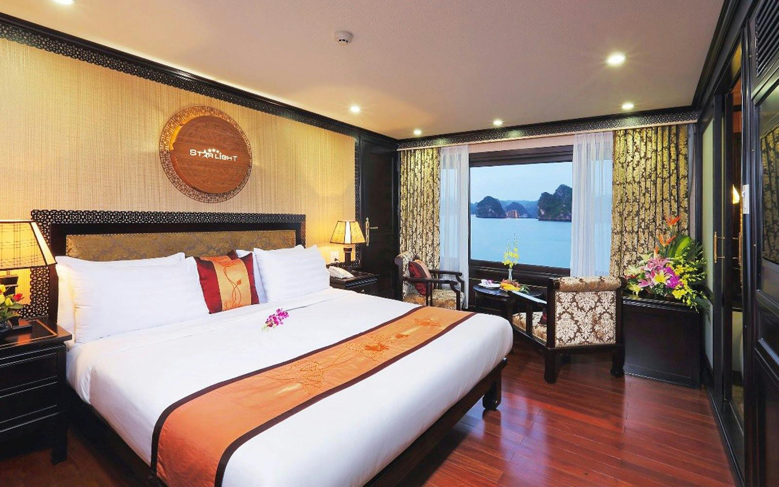 Luxurious cruise room with sea view in Halong Bay, featuring elegant decor and comfortable seating.
