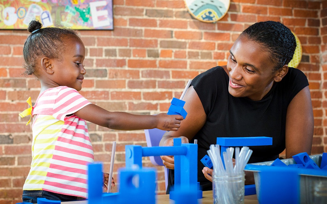 Child engaging in a building activity at Boston Children's Museum.