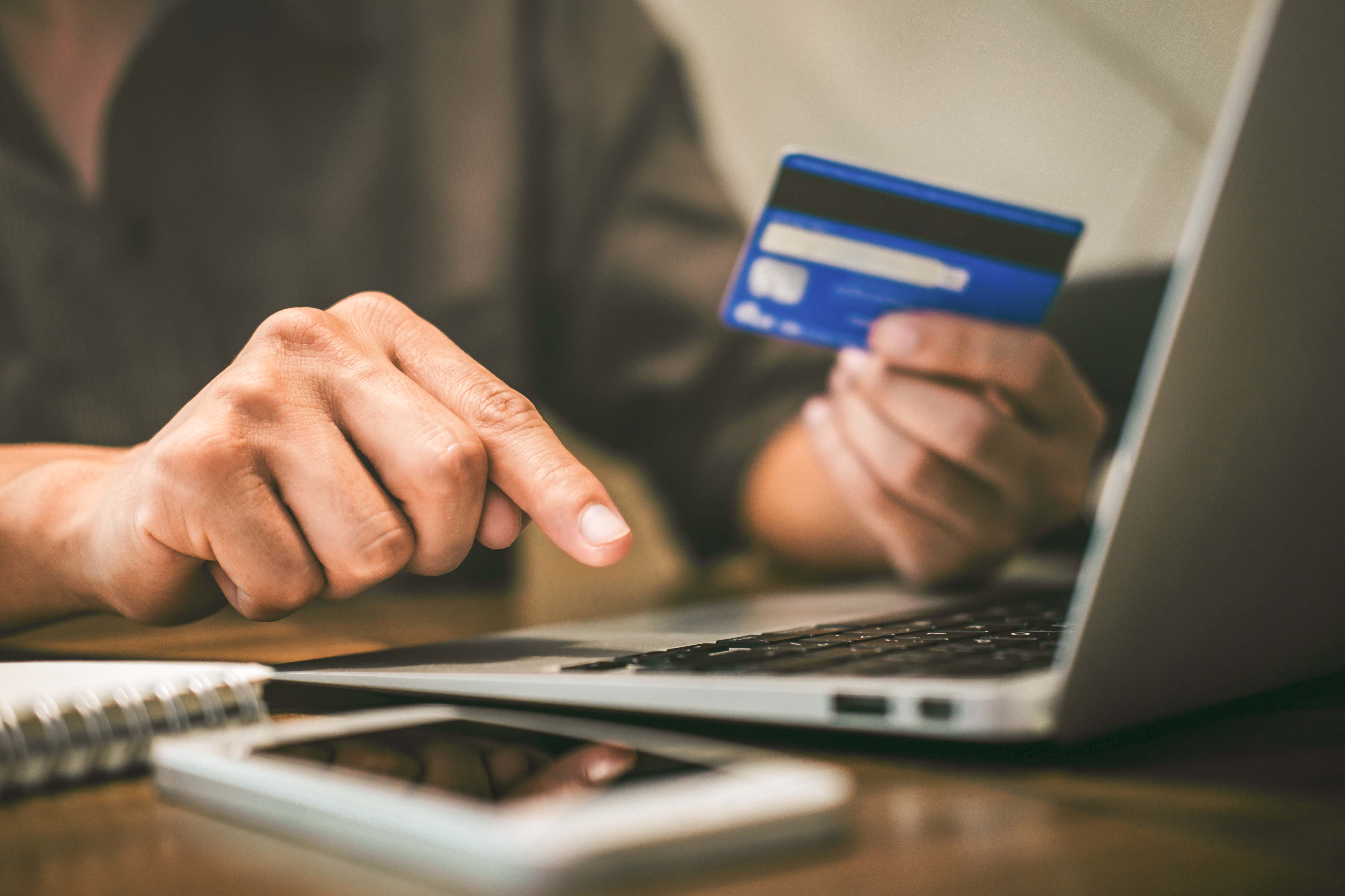 Person purchasing Verona Card online with credit card and laptop.