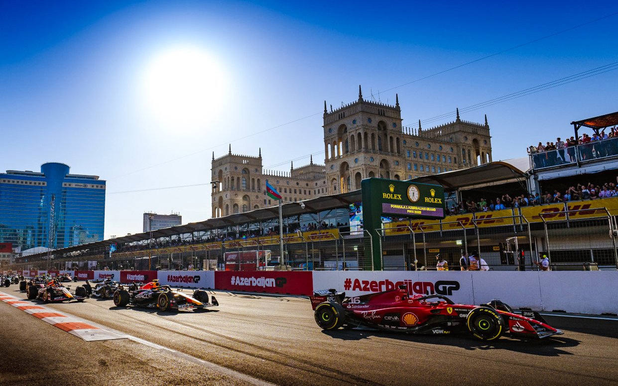 Formula 1 cars racing at Azerbaijan Grand Prix 2026 in Baku cityscape.