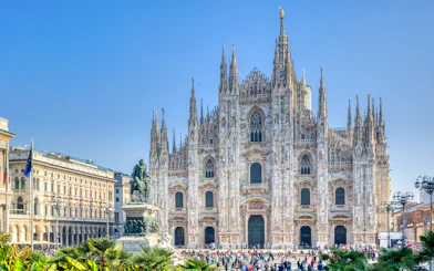 Milan Duomo Cathedral facade with tourists in the foreground.