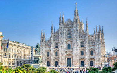 Milan Duomo Cathedral facade with tourists in the foreground.