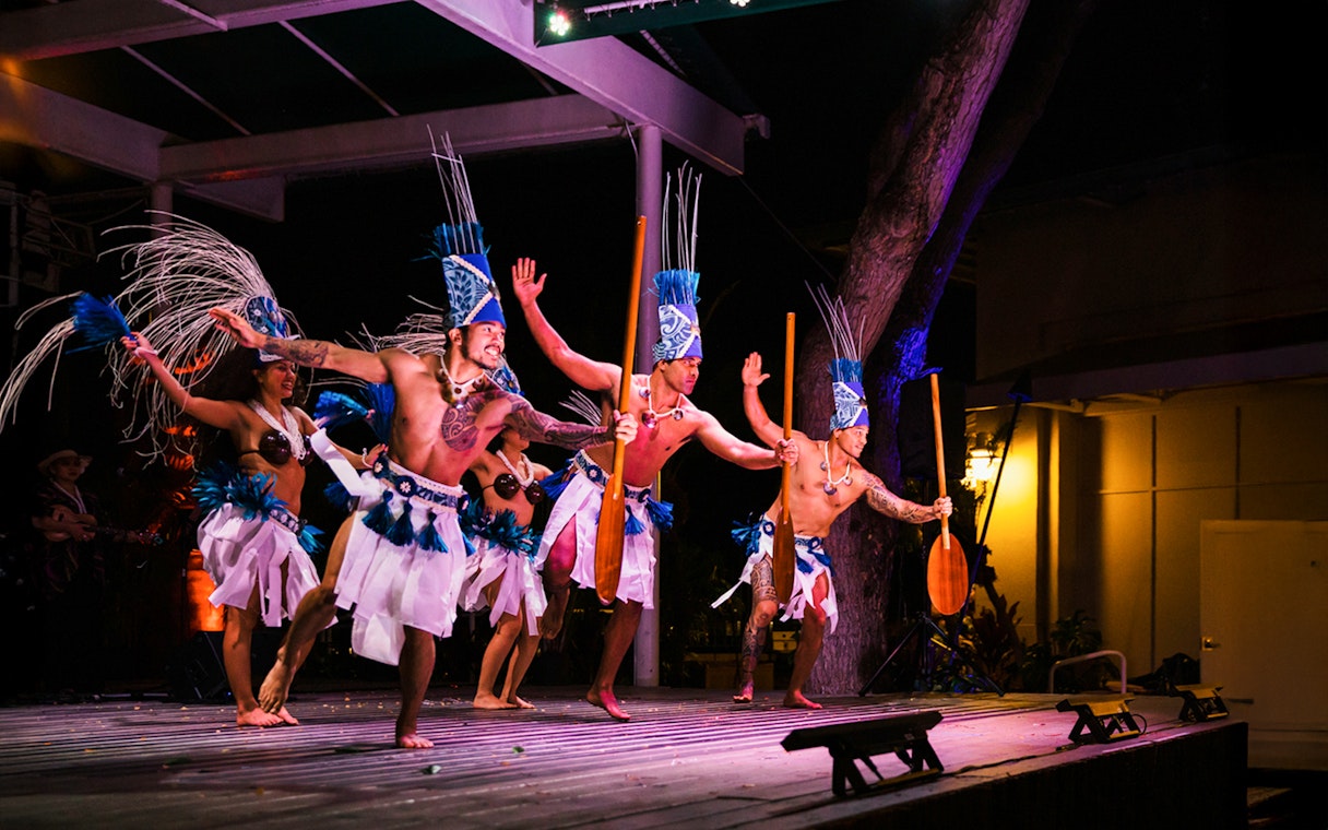 Performers in traditional attire at Moana Luau, Hawaii, showcasing a cultural dance.
