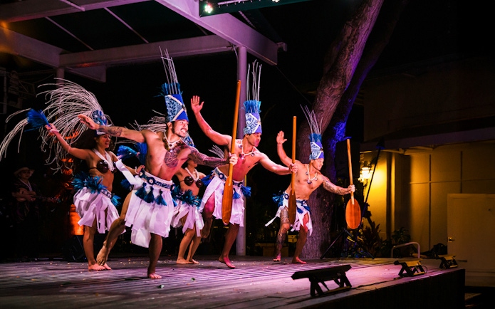 Performers in traditional attire at Moana Luau, Hawaii, showcasing a cultural dance.