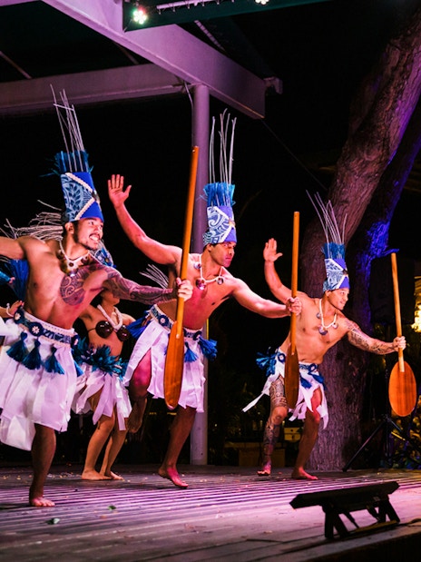 Performers in traditional attire at Moana Luau, Hawaii, showcasing a cultural dance.