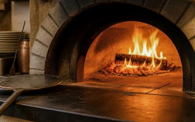 Wood-fired oven with flames for pasta class in Florence, Italy.