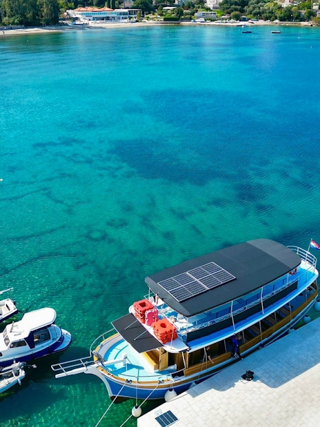 Boat docked at Dubrovnik harbor for Elaphite Islands tour with open bar and lunch.