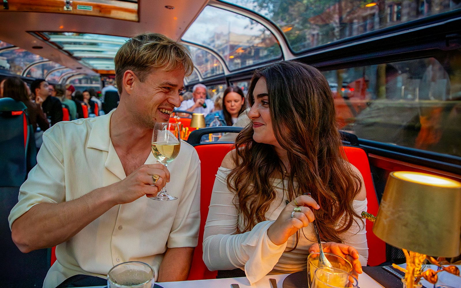 Guests enjoying wine on an Amsterdam dinner cruise with a four-course menu.