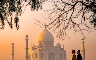 Taj Mahal at sunrise with visitors in foreground, Agra, India.