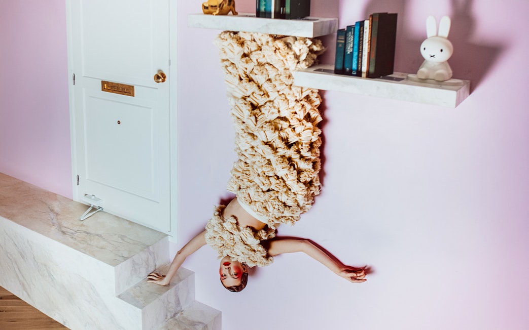 Visitors in Dutch Design Room at Upside Down Amsterdam with upside-down decor.