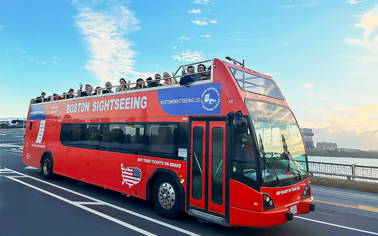 Tourists on a red sightseeing bus touring Boston.