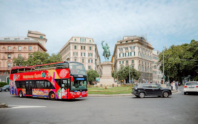 City Sightseeing bus near a statue in Genova, Italy.