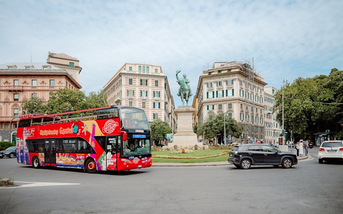 City Sightseeing bus near a statue in Genova, Italy.