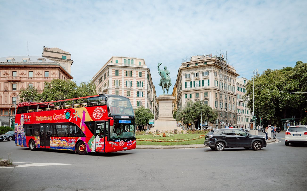 City Sightseeing bus near a statue in Genova, Italy.