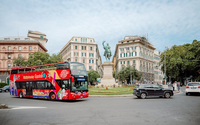 City Sightseeing bus near a statue in Genova, Italy.