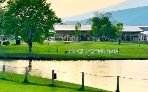 Prince Shopping Plaza in Karuizawa with green lawn and pond in foreground.