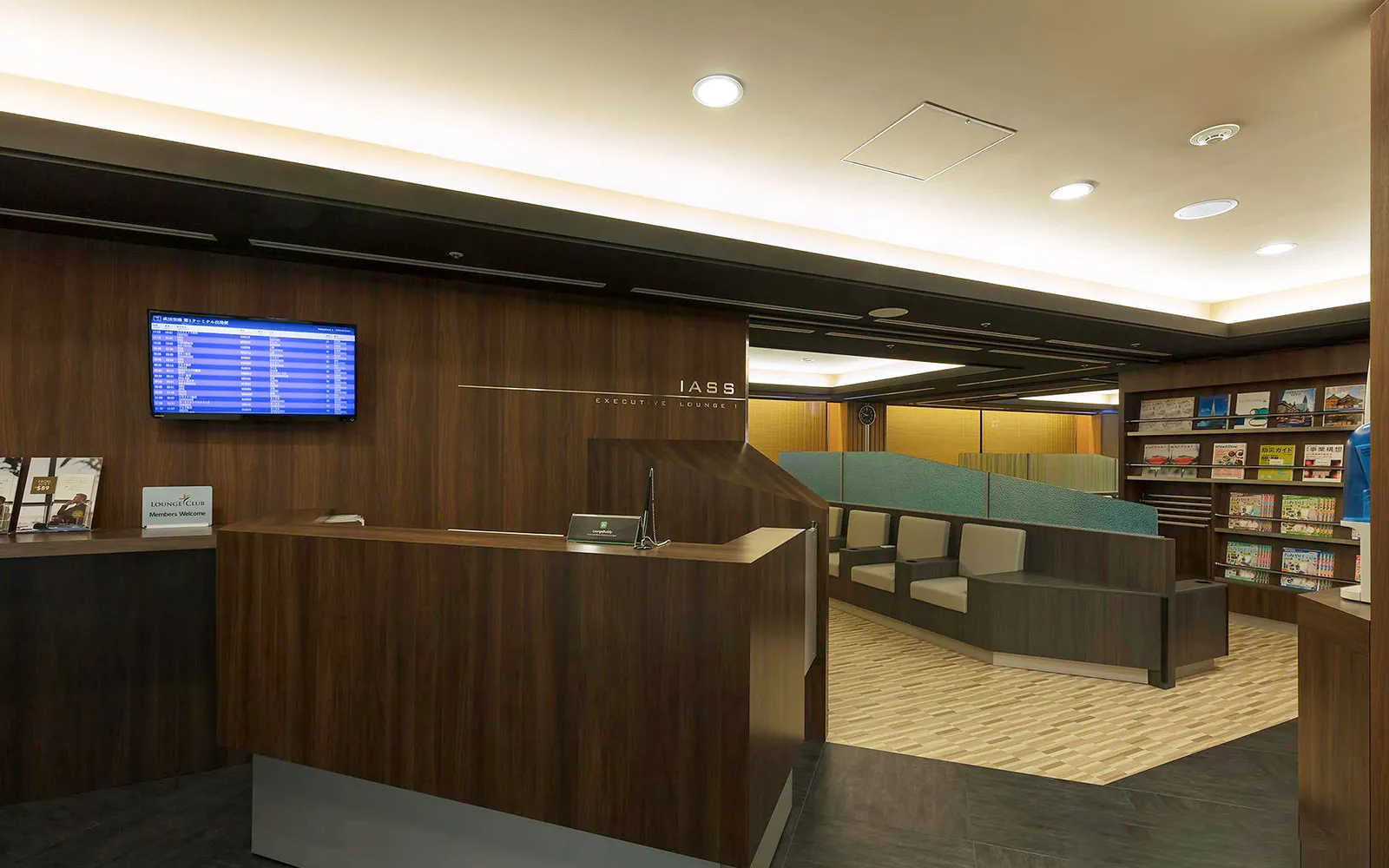 Waiting area at Narita International Airport Terminal 1 lounge with seating and flight information display.