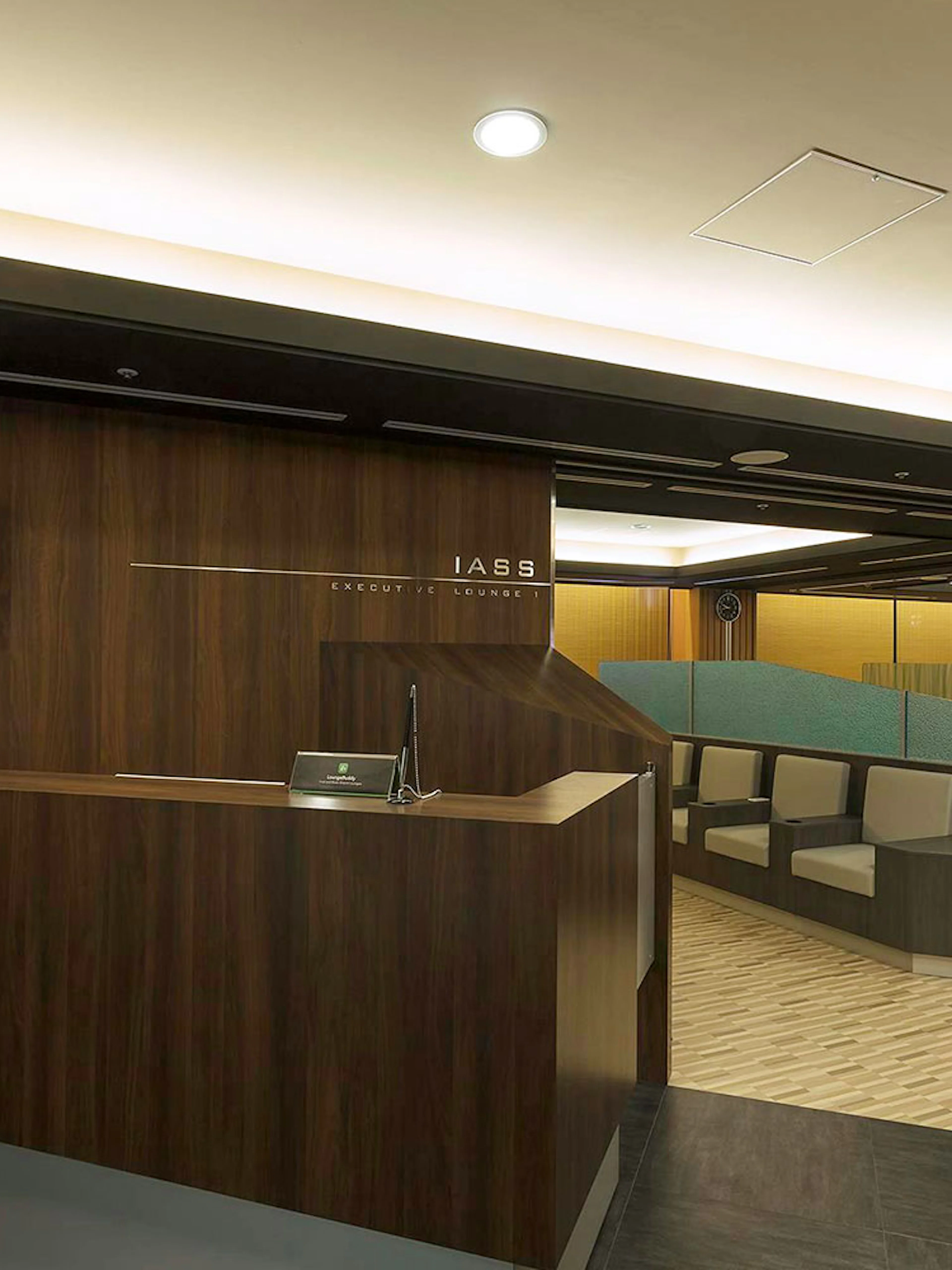 Waiting area at Narita International Airport Terminal 1 lounge with seating and flight information display.
