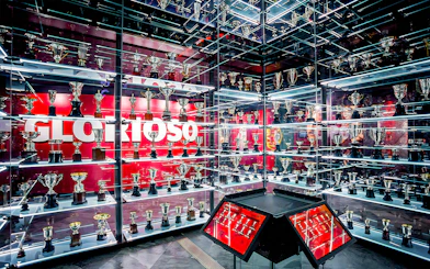 Benfica Stadium museum trophy display with numerous awards on shelves.