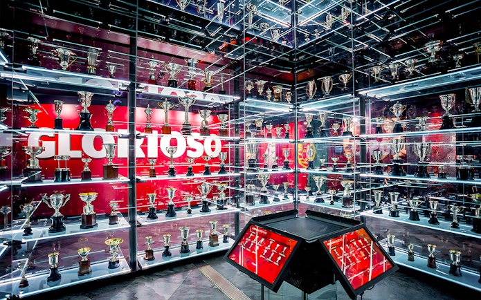 Benfica Stadium museum trophy display with numerous awards on shelves.