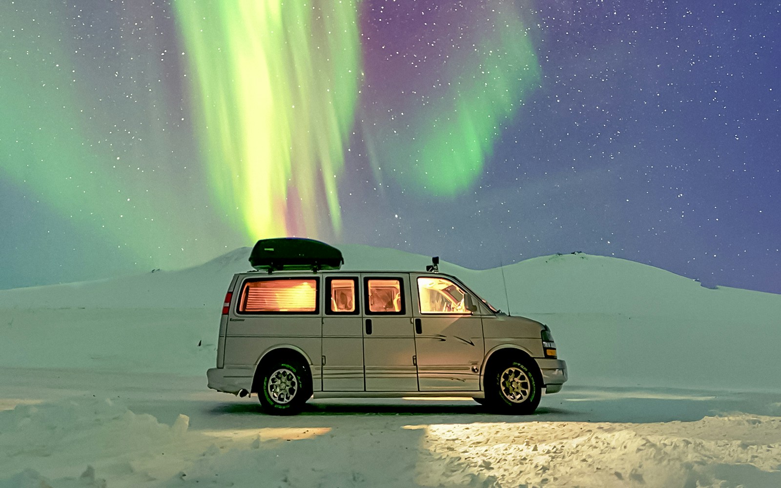 Minivan under Northern Lights during premium small group tour.