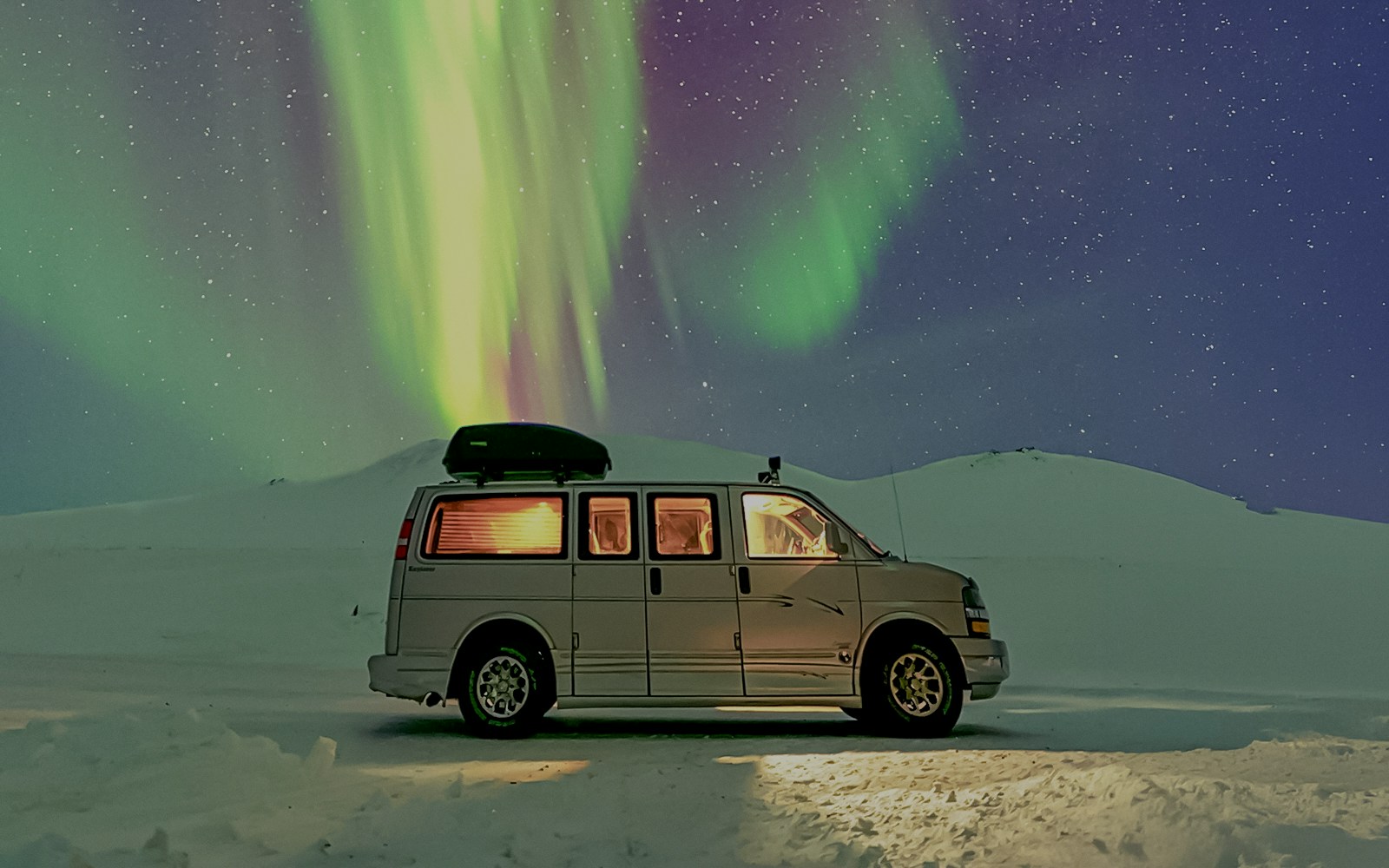 Minivan under Northern Lights during premium small group tour.