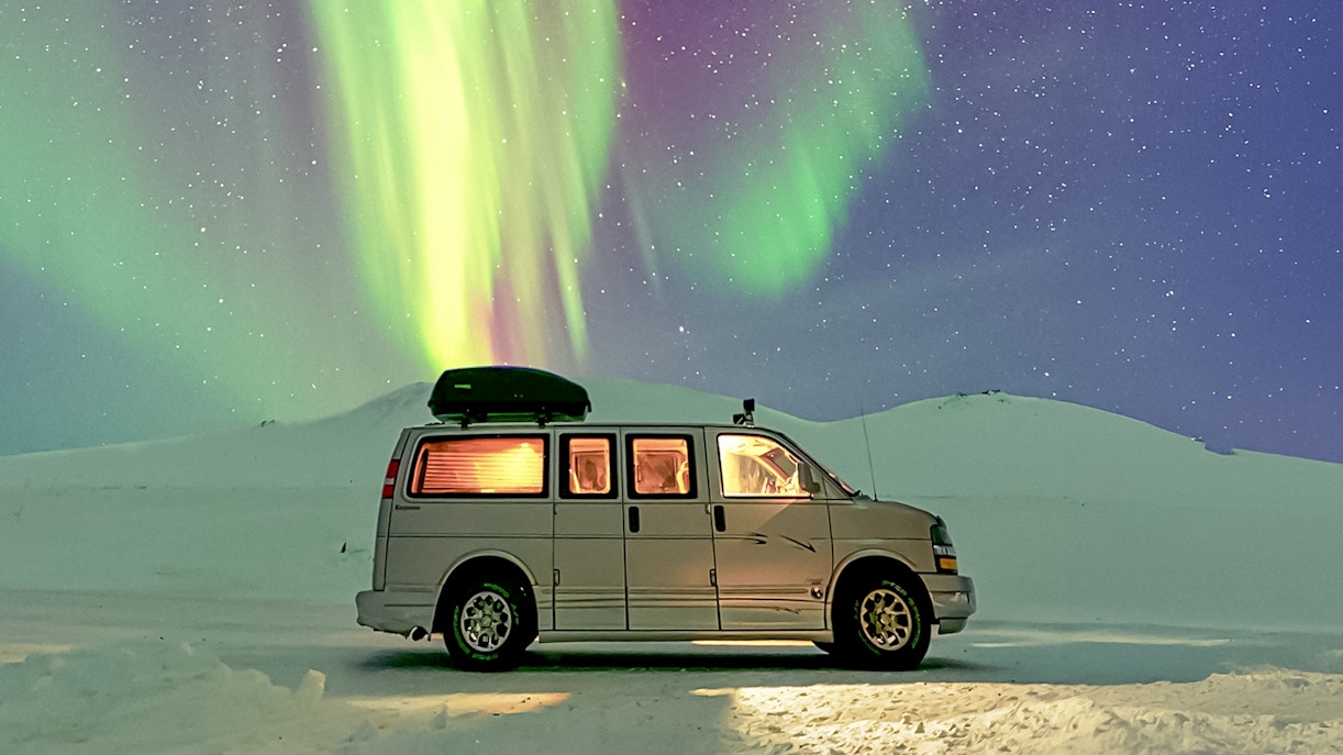 Minivan under Northern Lights during premium small group tour.
