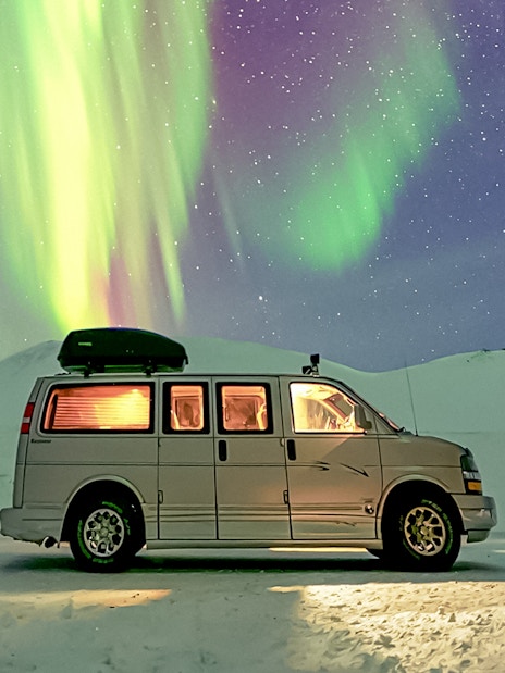 Minivan under Northern Lights during premium small group tour.