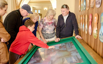 Guests interacting with a digital exhibit at Mozart Interactive Museum in Prague.