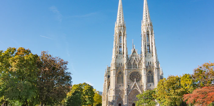 Votive Church in Vienna with twin spires and surrounding trees.
