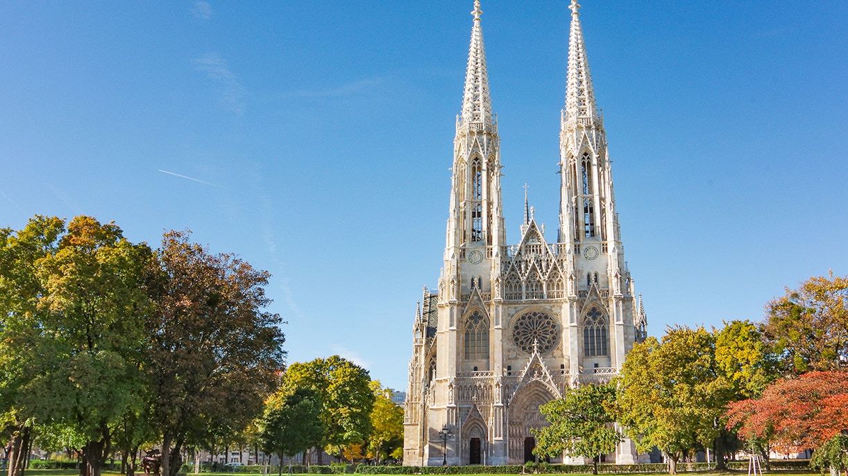 Votive Church in Vienna with twin spires and surrounding trees.