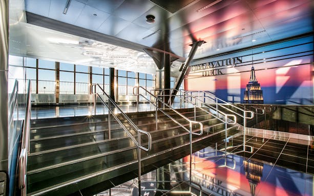 Empire State Building Observatory interior with view of New York City skyline.