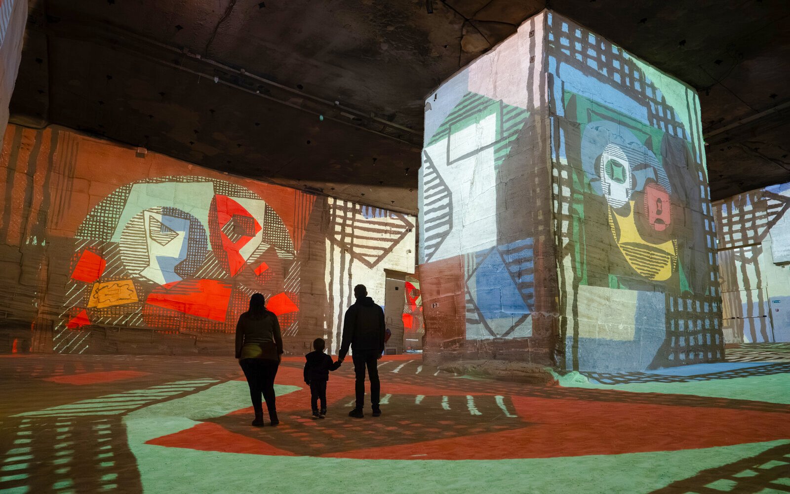 Visitors viewing Picasso projections at Carrières des Lumières exhibit.
