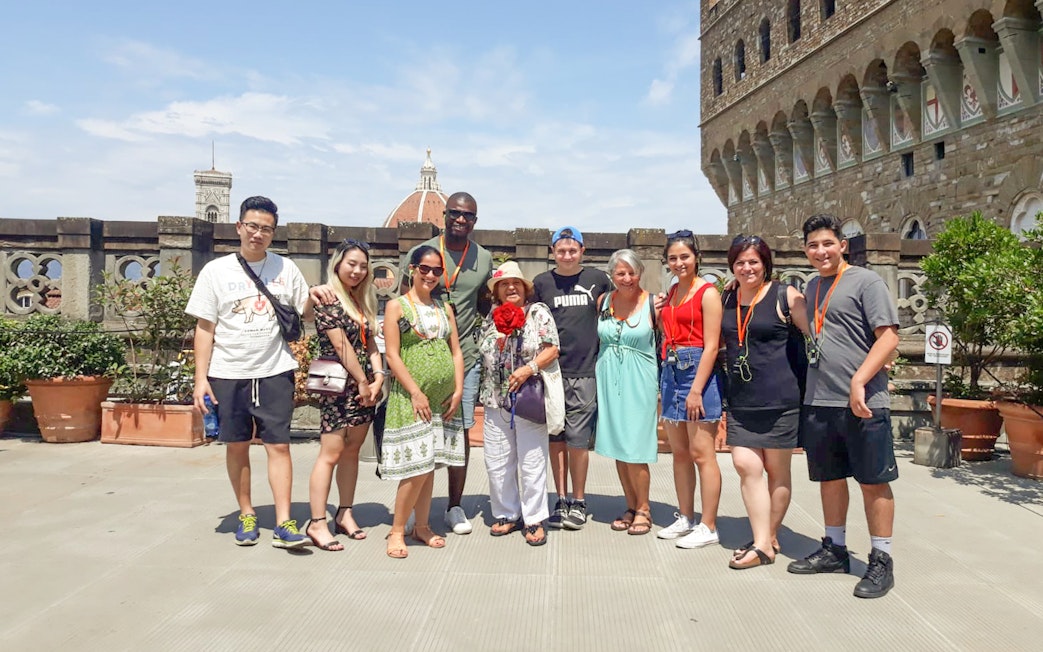 Group of tourists on a Palazzo Vecchio tour in Florence, Italy, with the Duomo in the background.