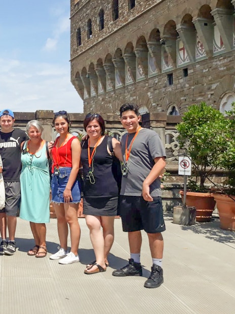Group of tourists on a Palazzo Vecchio tour in Florence, Italy, with the Duomo in the background.