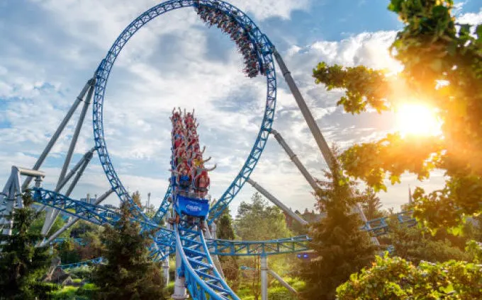 Roller coaster loop at Europa-Park with riders under a sunny sky.