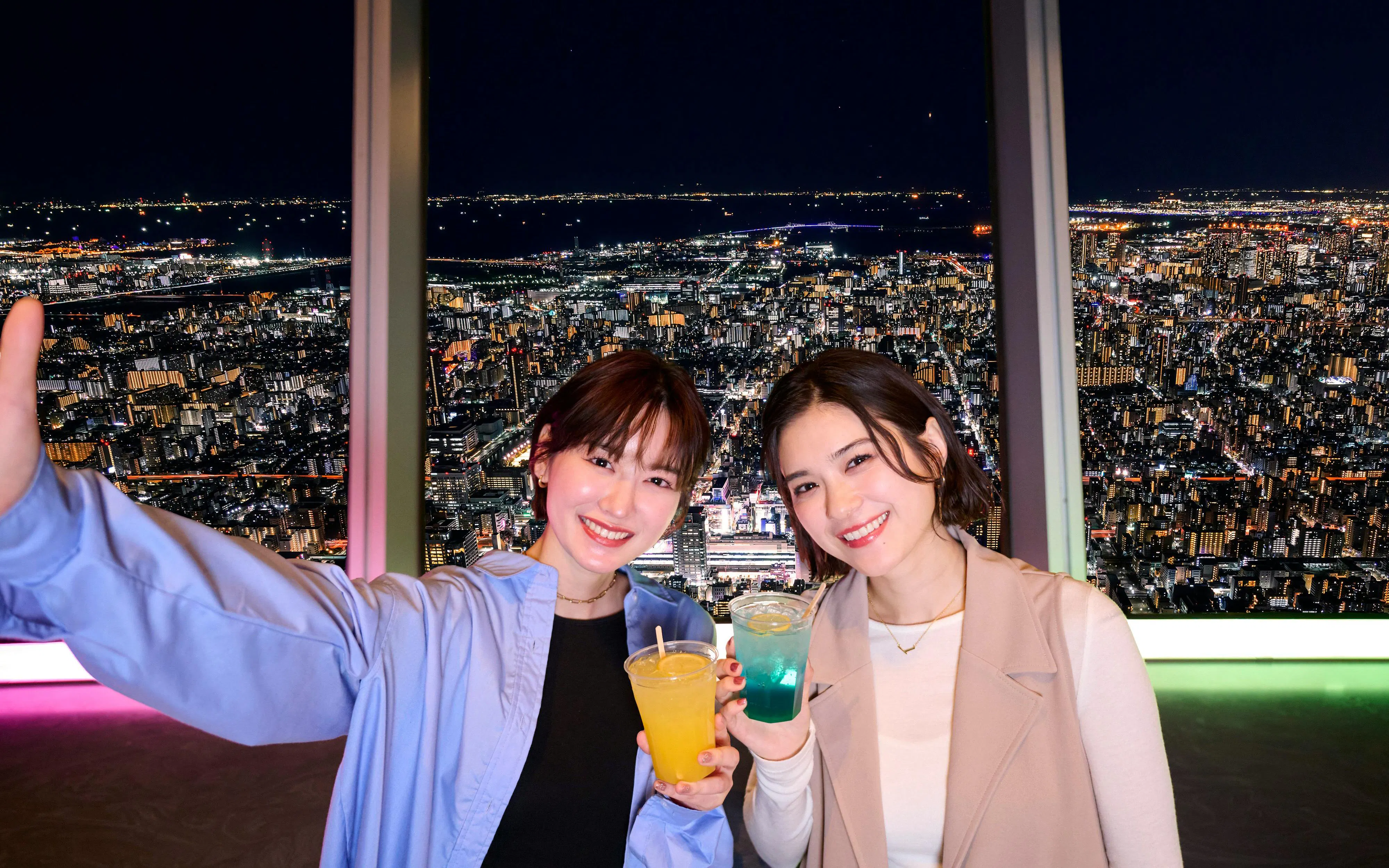 Visitors enjoying drinks with a night view from Tokyo Skytree Tembo Deck.
