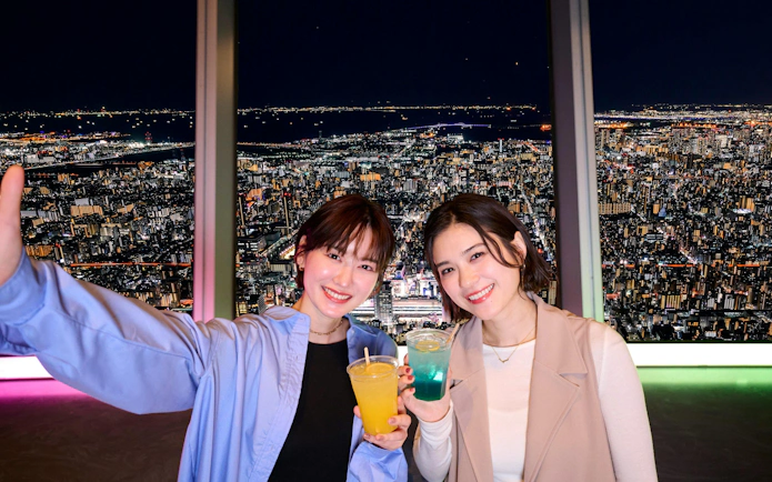 Visitors enjoying drinks with a night view from Tokyo Skytree Tembo Deck.