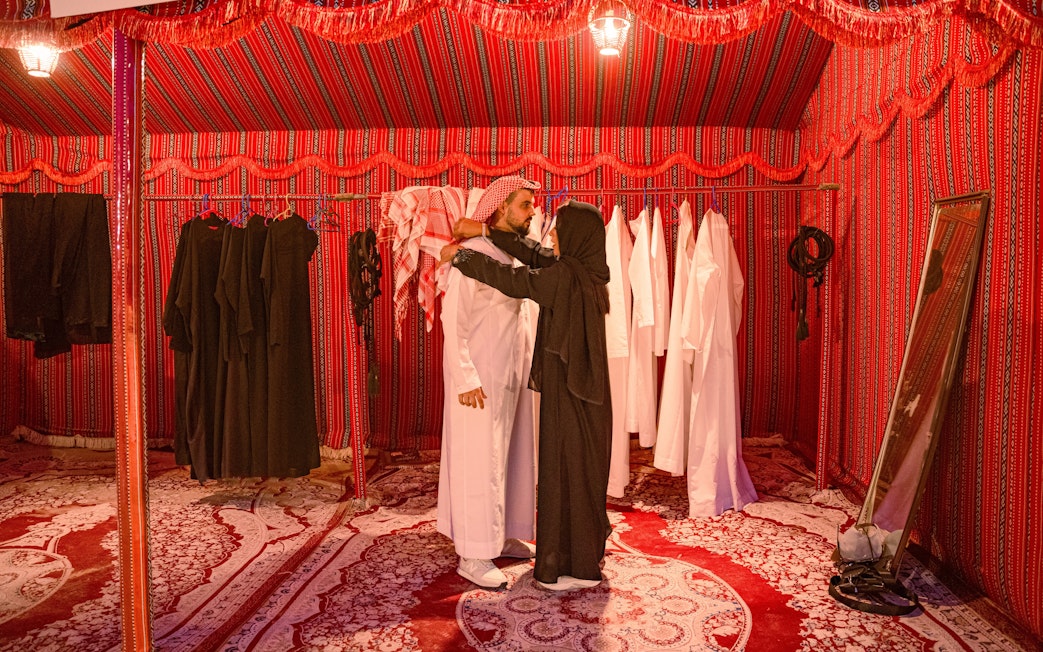 People dressing in traditional Arab attire inside a tent during a desert safari in Abu Dhabi.