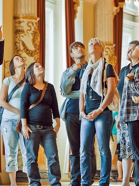Tour group listening to a guide inside the ornate Semperoper, Dresden.