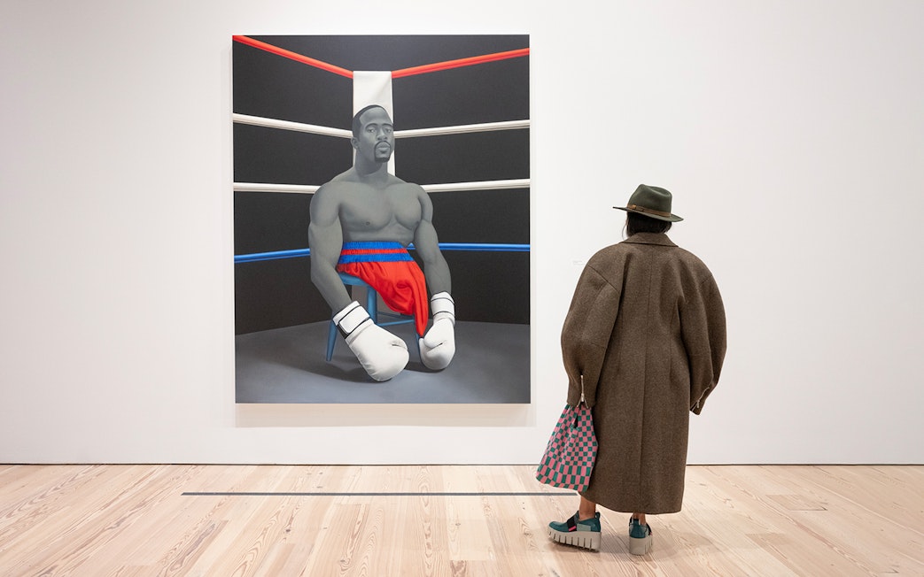 Visitor viewing Amy Sherald painting of a boxer at Whitney Museum of American Art.