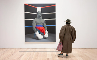 Visitor viewing Amy Sherald painting of a boxer at Whitney Museum of American Art.