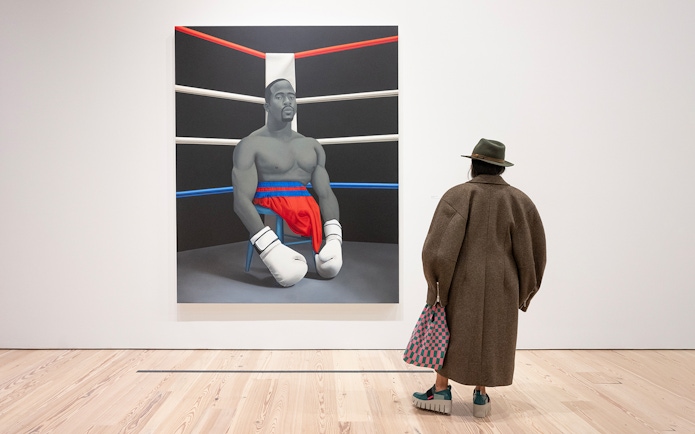 Visitor viewing Amy Sherald painting of a boxer at Whitney Museum of American Art.