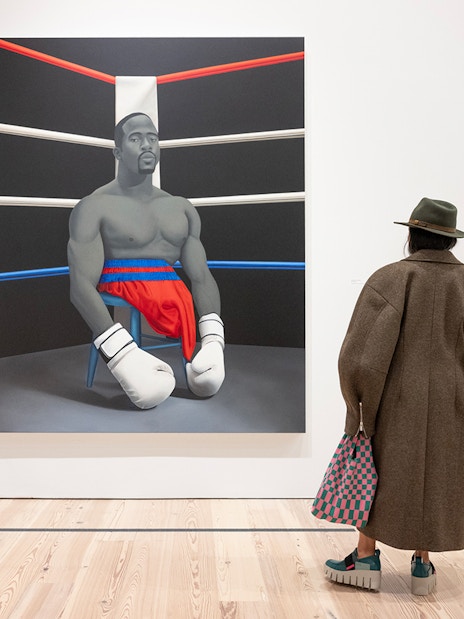 Visitor viewing Amy Sherald painting of a boxer at Whitney Museum of American Art.