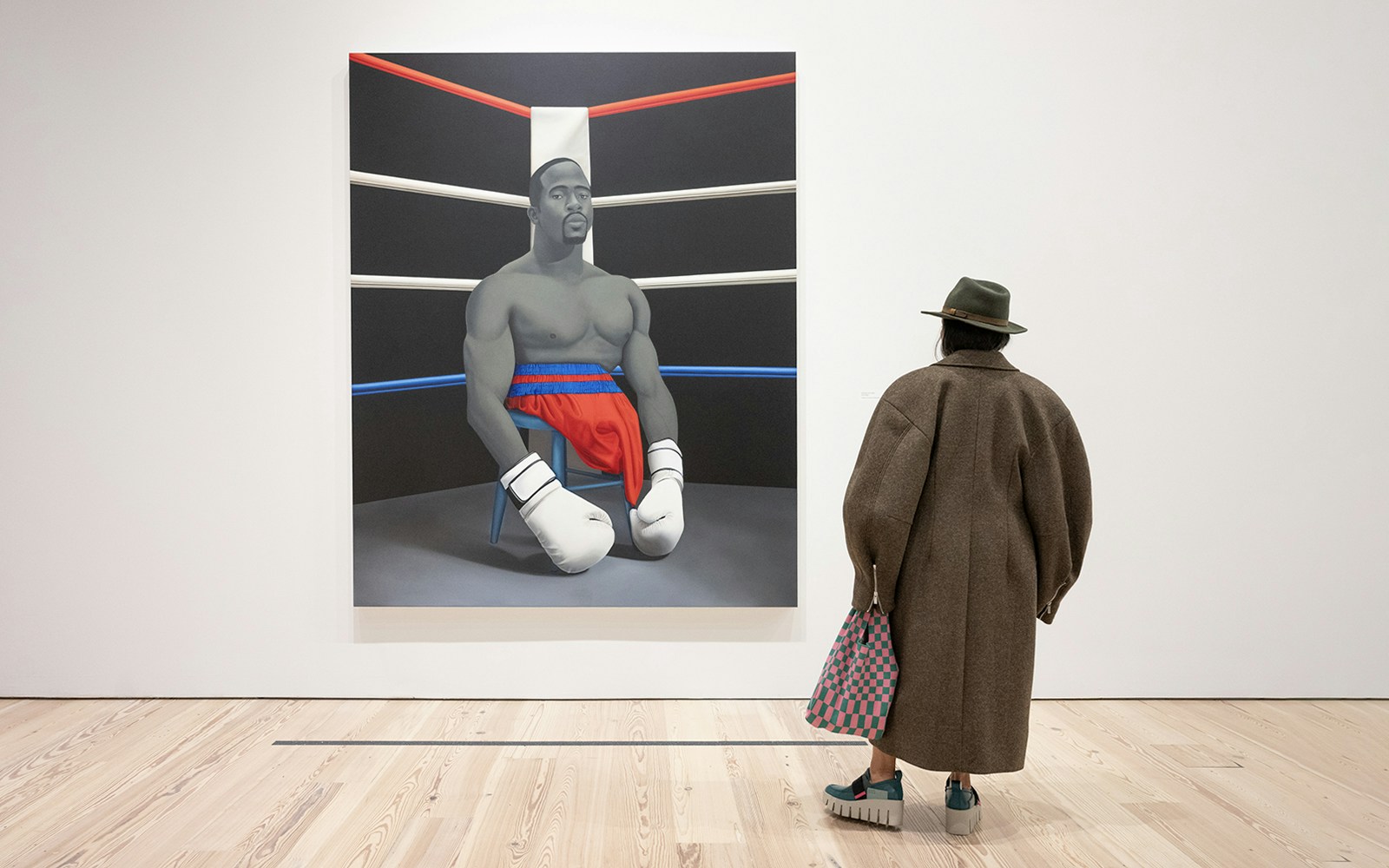 Visitor viewing Amy Sherald painting of a boxer at Whitney Museum of American Art.