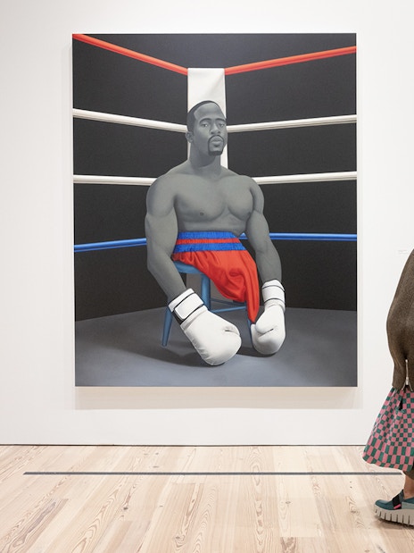Visitor viewing Amy Sherald painting of a boxer at Whitney Museum of American Art.